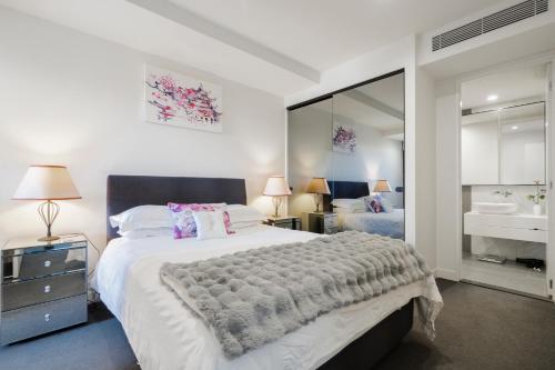 a bedroom with a large bed and a mirror at Executive Two bedroom & two bathrooms in Melbourne