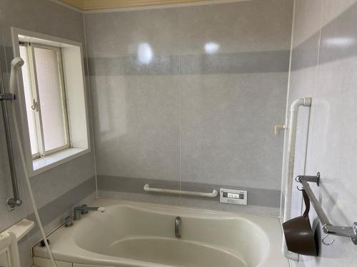 a bath tub in a bathroom with a window at 湖を望む一軒家 in Wakasa