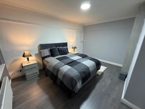a bedroom with a black and white bed and two lamps at Kings Lodge in Manchester