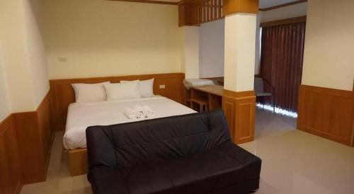 een slaapkamer met een bed en een stoel erin bij Loei Residence in Ban Tha Phae