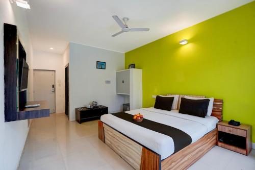 ein Schlafzimmer mit einem großen Bett mit einer grünen Wand in der Unterkunft Townhouse Morjim Beach North Goa Formerly Bay Breeze Hotels & Resorts in Chopdem