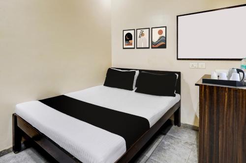 a bed in a room next to a podium at Hotel O MA Chidambaram Stadium Formerly Sarvanas Park in Chennai