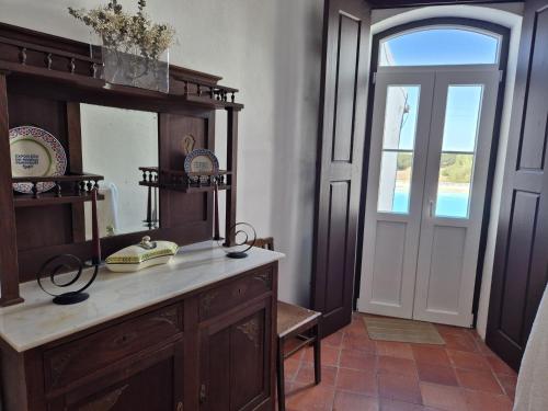 a bathroom with a wooden vanity and a mirror at Herdade do Vidigal in Montemor-o-Novo