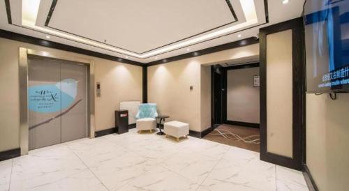 een kamer met een tv, twee stoelen en een scherm bij Xana Hotelle Jinan Daminghu North Gate in Jinan