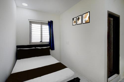 een witte kamer met een bed en een raam bij Hotel O Film City Hyderabad Formerly RJ Residency in Pedda Ambarpet