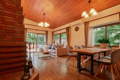 a living room with a wooden table and chairs at Villa Noël Hakone Chimney Luxury Onsen & Sauna Retreat in Hakone