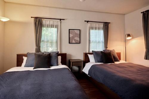 um quarto com 2 camas e 2 janelas em Noël Hakone Chimney em Hakone