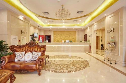 a living room with a couch and a chandelier at Vienna Shanghai Chongming Changxing Island in Dongxing