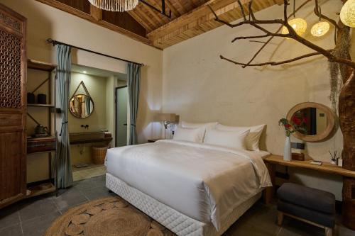 DongpuにあるHuazhu Luxury Lotus Twilight Fossil Museum B&Bの大きな白いベッドと机のある寝室