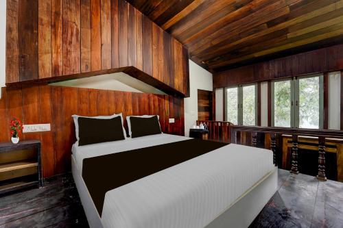 a bedroom with a large bed and wooden walls at Super Collection O Chalakkudy River Annamanada Formerly Svasthya Retreat in Māla