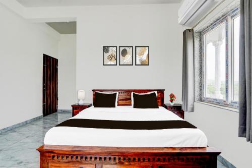 a bedroom with a large bed and two windows at Super Hotel O Mehta College And Institute Of Technology Formerly Lara Heritage in Jaipur