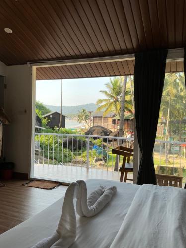 a bedroom with a bed and a large window at Ourem Palace in Palolem