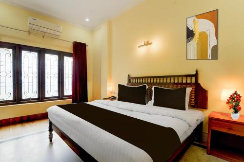a bedroom with a large bed and windows at Super Collection O Kangarappady Formerly Cochin Residency in Kakkanad