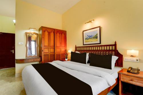 a bedroom with a large bed and a telephone at Super Collection O Kangarappady Formerly Cochin Residency in Kakkanad