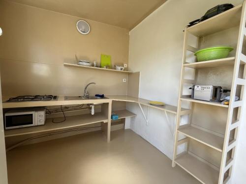 a kitchen with a counter with a microwave and a shelf at Beach Studio 24h24 & 7j7 in Petite Île
