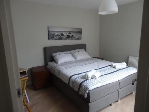 a bedroom with a bed with two pillows on it at Zilvermeeuw - Drieplassenweg in Katwijk