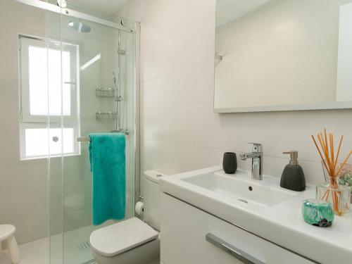 a white bathroom with a sink and a toilet at Bungalow Playa del Inglés JFGI by VillaGranCanaria in Playa del Ingles