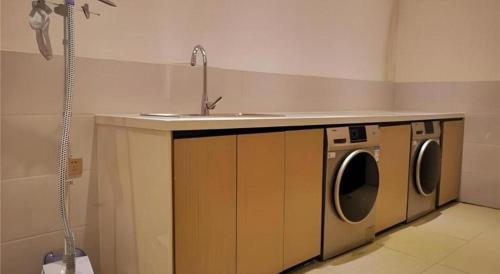 a bathroom with a sink and a washing machine at City Comfort Inn Mianyang Southwest University Of Science And Technology in Qinglianchang