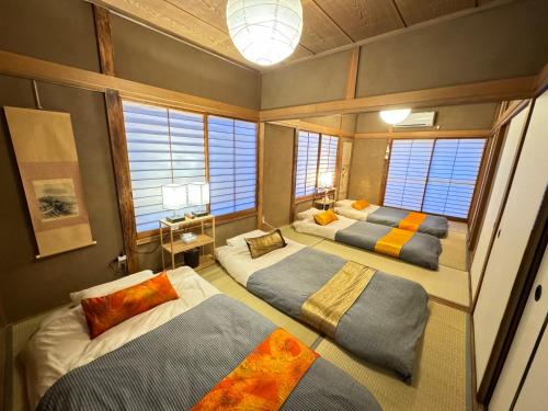 a room with three beds in it with windows at Ai dear KAWAGOE in Kawagoe