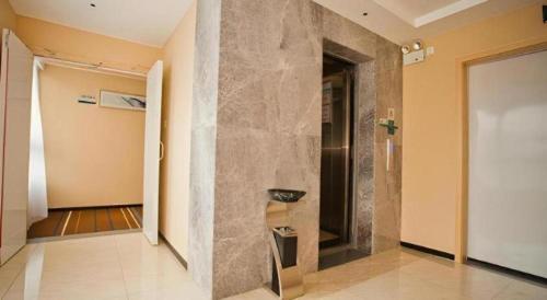 a hallway with a stone wall and a doorway at City Comfort Inn Deyang Wenmiao Square Gymnasium in Deyang