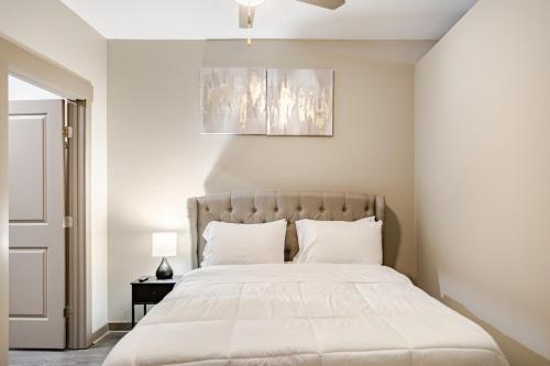 a bedroom with a large bed with white sheets at Cozy Uptown apartment with Gym and Swimming pool in Charlotte