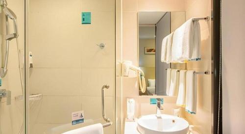 Un baño blanco con lavabo y ducha en City Comfort Inn Nanning Qingxiu Wanda Dongge Road Metro Station, en Nanning