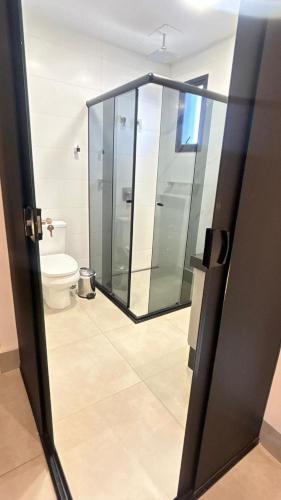 un bagno con doccia in vetro e WC di Charmant Vertigo a Campo Grande