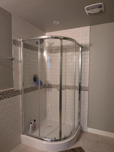 a shower with a glass enclosure in a bathroom at 2-Room Suite in South Edmonton in Edmonton