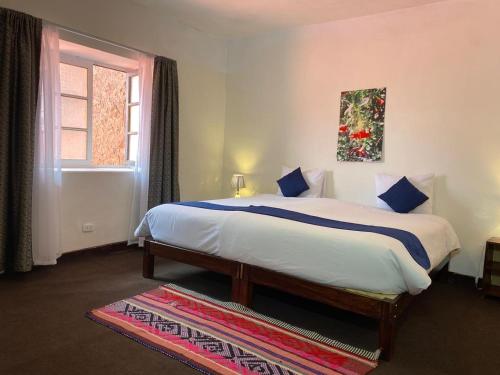 a bedroom with a bed and a window at Runa House in Cusco