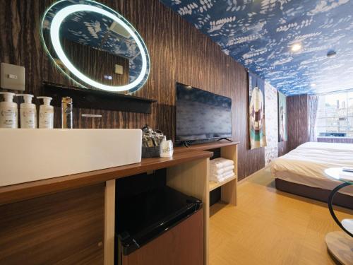 a bathroom with a sink and a bed in a room at 泊るHouse千葉駅1分 J - 東京ディズニーランドまで30分 線路傍騒音あり in Chiba