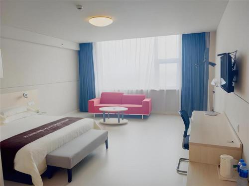 een ziekenhuiskamer met een bed en een bank bij Jinjiang Inn Hengshui Anping in Anping