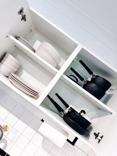 a white kitchen with plates and dishes on shelves at Fitaa House Southampton in Southampton