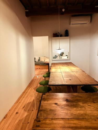 a room with a large wooden table and green chairs at papan room in Miyota