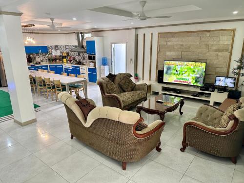 ein Wohnzimmer mit Sofas, einem TV und einem Tisch in der Unterkunft KGH Villa Rental in Cuayan