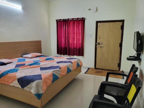 a bedroom with a bed and a chair and a door at Holidaypark in Araku
