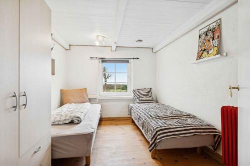 een kamer met twee bedden en een raam bij Country Stay In Cosy Farmhouse With Horses in Bøvlingbjerg
