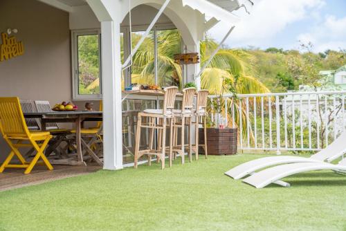 un patio avec une table et des chaises sur un balcon dans l'établissement OFFRE NOËL ! CASA LYDIE Évasion créole avec piscine, à Saint-François