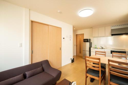 a living room and kitchen with a couch and a table at Elle Maison大森 102 in Tokyo