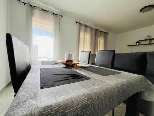 een eettafel met stoelen en een groot raam bij Castillo Dream en San Bartolome de Tirajana in Castillo del Romeral