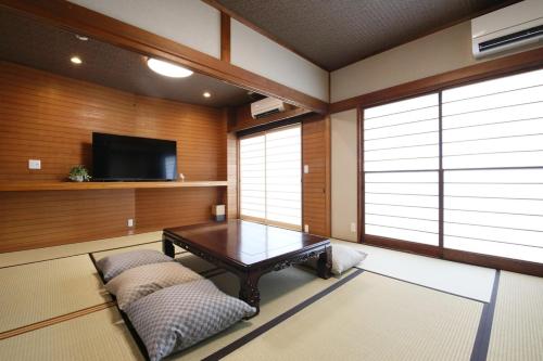 a living room with a table and a tv at Kiwaya 貴和家 - Fuji Numazu BASE - in Numazu