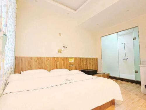 a bedroom with a large white bed and a shower at The Cozy Nook in Zhangjiajie