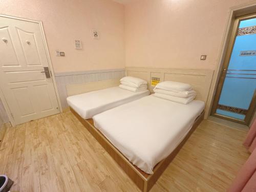 two beds in a small room with a window at The Cozy Nook in Zhangjiajie