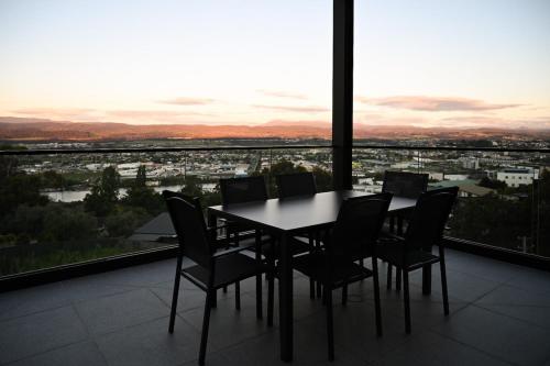 a table and chairs in a room with a view at Tamar Views in Inveresk