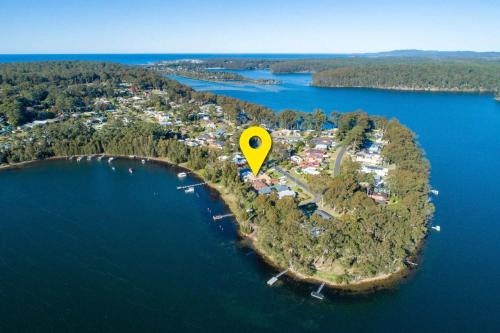 an island with a yellow marker on it in the water at Lakeside - relaxed 3 BR waterfront retreat in Burrill Lake