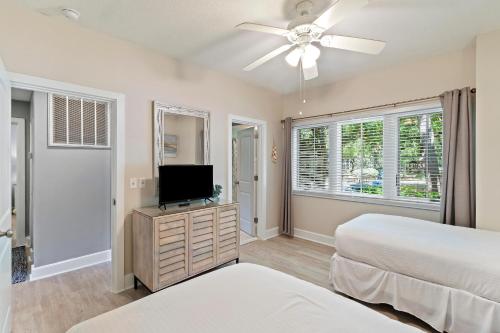 Un dormitorio con dos camas y un televisor de pantalla plana. en TP4937: 4937 Turtle Point, en Kiawah Island