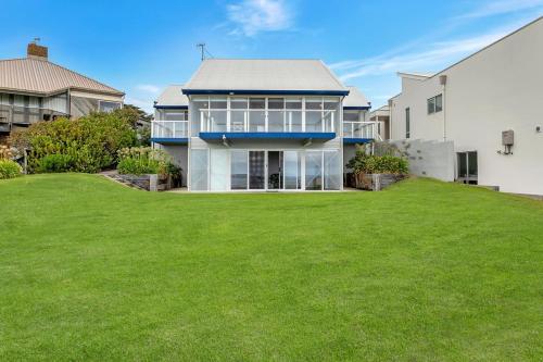 a house with a large lawn in front of it at 115 Seagull - Beachfront - Wi-Fi - No Linen Included in Hayborough