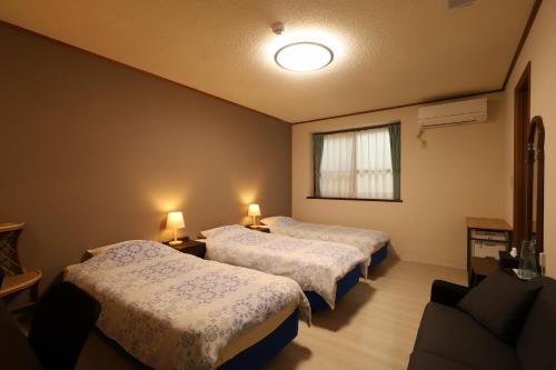 a room with two beds and a window at ペンション星砂 in Zamami