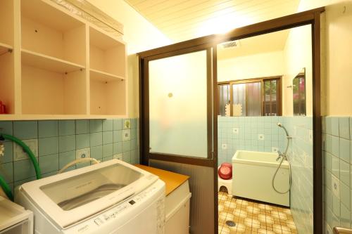 a kitchen with a washing machine and a tub at ペンション星砂 in Zamami