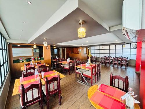 a restaurant with tables and chairs in a room at Hotel Mangala Temple View in Guruvāyūr