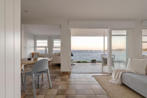 a living room and dining room with a view of the ocean at Fogo @ Ethel & Ode’s in Bundeena
